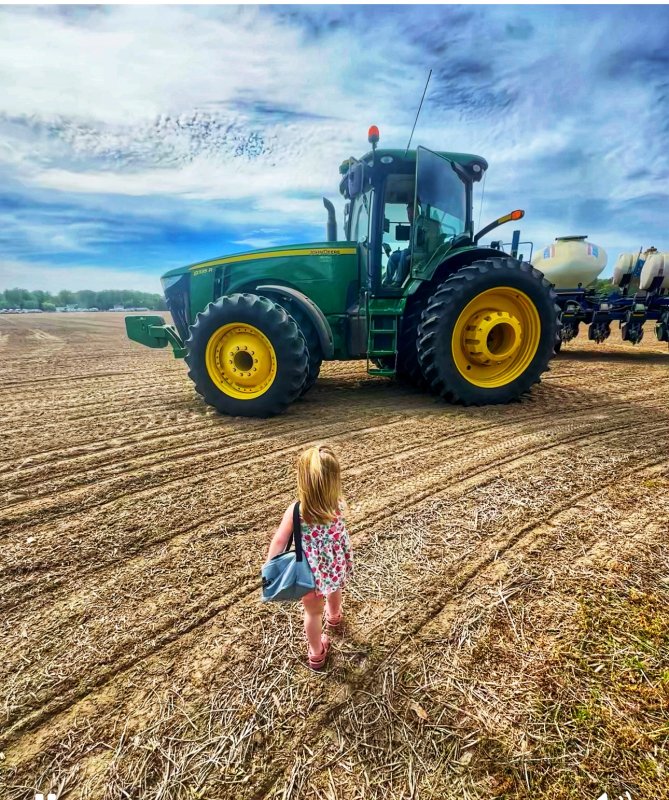 The DEFB first-place photo for 2025 shows a young girl carrying lunch to a tractor-driving farmer.